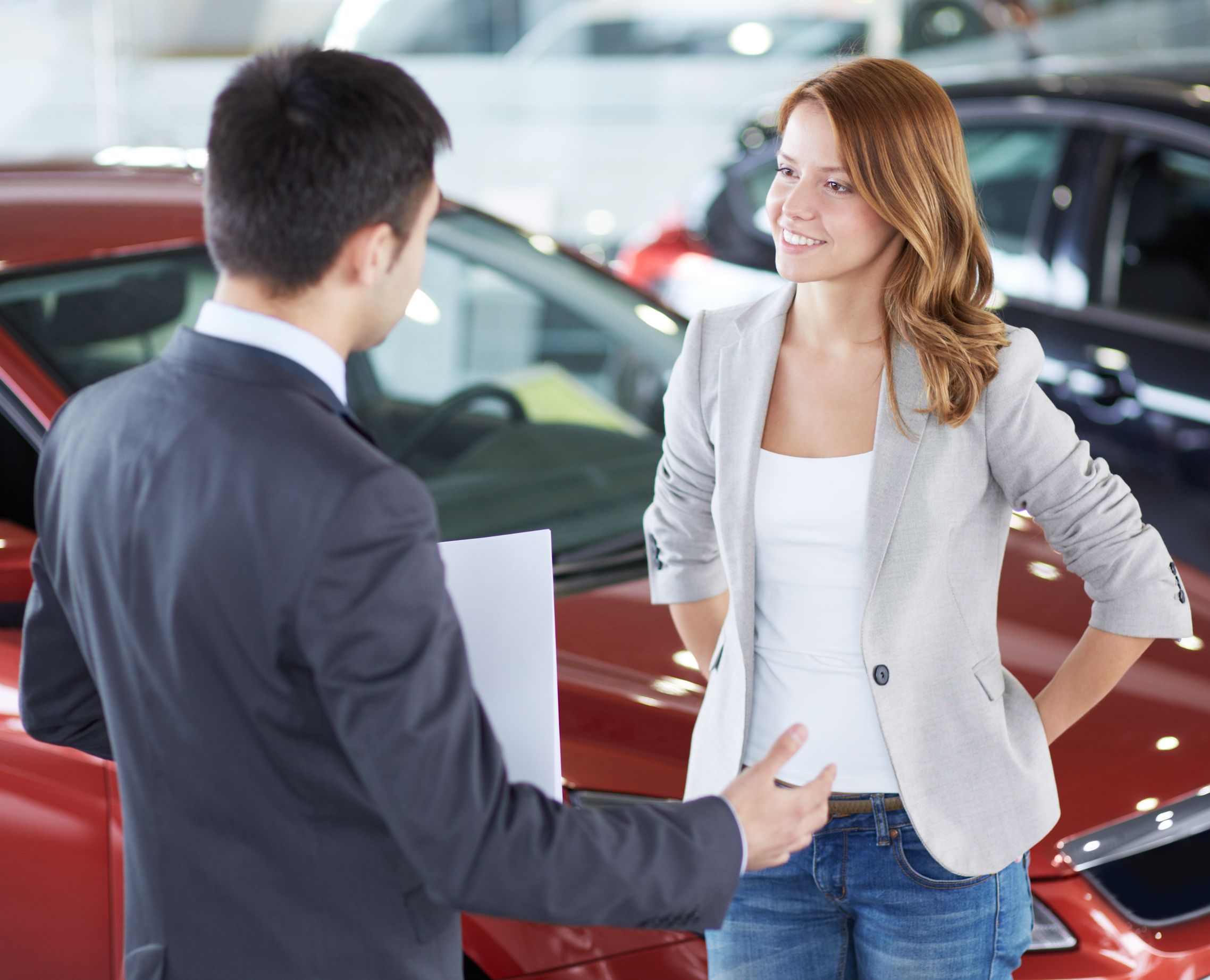 21817846_l-car-dealer-and-happy-female-communicating-in-automobile-center