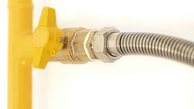 Yellow gas pipe with a valve. White background.